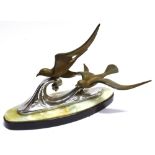 AN ART DECO GROUP modelled as two birds flying above stylised waves, on oval plinth base signed '