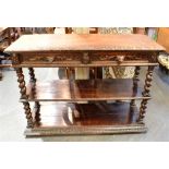 A CARVED OAK THREE TIER BUFFET with spiral turned uprights, pair of lion mask handle drawers to