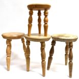 FOUR ASH AND ELM MILKING STOOLS the circular seats approx 29cm diameter, on turned supports,