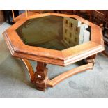 AN OCTAGONAL OAK COFFEE TABLE with glass inset top, on square inverted baluster supports, 112cm wide