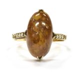 A 9CT GOLD HARDSTONE SET DRESS RING With small half seed pearl at shoulders, the oval cabochon cut