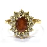 A GARNET AND WHITE CUBIC ZIRCONIA SET OVAL CLUSTER RING the central garnet approx. 8 x 6mm, claw