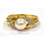 A MODERN SINGLE CULTURED PEARL SET 18CT GOLD RING with diamond set cross over shoulders, the