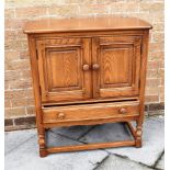 AN ERCOL CREEDENCE CUPBOARD FROM THE 'OLD COLONIAL' RANGE in 'Golden Dawn' colour, with two door