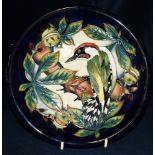 A MOORCROFT POTTERY PLATE with tubelined decoration of a green woodpecker in horse chestnut tree, on