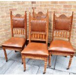 A SET OF FOUR CARVED OAK FRAMED DINING CHAIRS with leather upholstered seats and backs