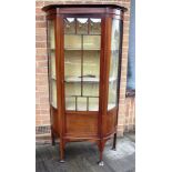 MAHOGANY BOWFRONTED DISPLAY CABINET, with a central door and raised on tapering legs and spade