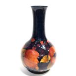 A LARGE MOORCROFT POTTERY VASE DECORATED IN THE 'POMEGRANATE' PATTERN on a dark blue ground, painted