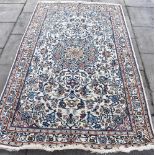 A CREAM GROUND RUG with blue/red foliate decoration within decorative border, 155cm x 258cm