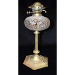 A LATE VICTORIAN/EDWARDIAN OIL LAMP BASE with cut glass reservoir of lobed form, on brass column