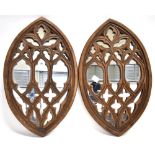 A PAIR OF COMPOSITION WALL MIRRORS of elliptical form, with pierced and carved Gothic oak style