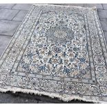 A CREAM GROUND RUG with blue/beige foliate decoration within decorative border, 197cm x 290cm