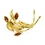 AN 18CT GOLD GARNET SET SPRAY BROOCH the spray of stylised design, set with three marquise cut