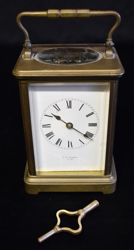 A BRASS CARRIAGE CLOCK the enamel dial with Roman numerals, inscribed 'T R RUSSELL P*RIS', 15cm high