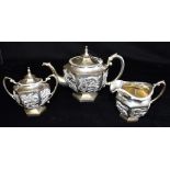 A CHINESE SILVER EXPORT THREE PIECE TEA SET with raised dragon motif decoration, the hexagonal