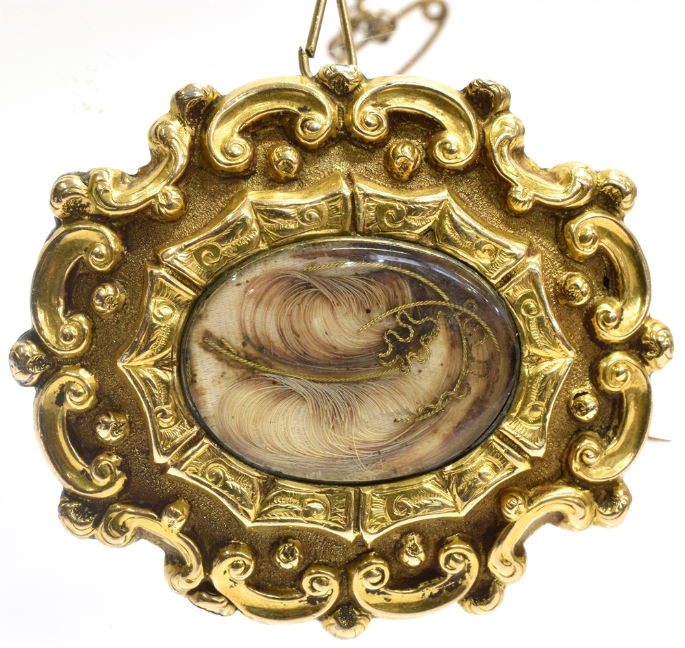 A VICTORIAN YELLOW GOLD BROOCH the oval brooch with wisps of hair to glazed central compartment with