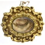 A VICTORIAN YELLOW GOLD BROOCH the oval brooch with wisps of hair to glazed central compartment with