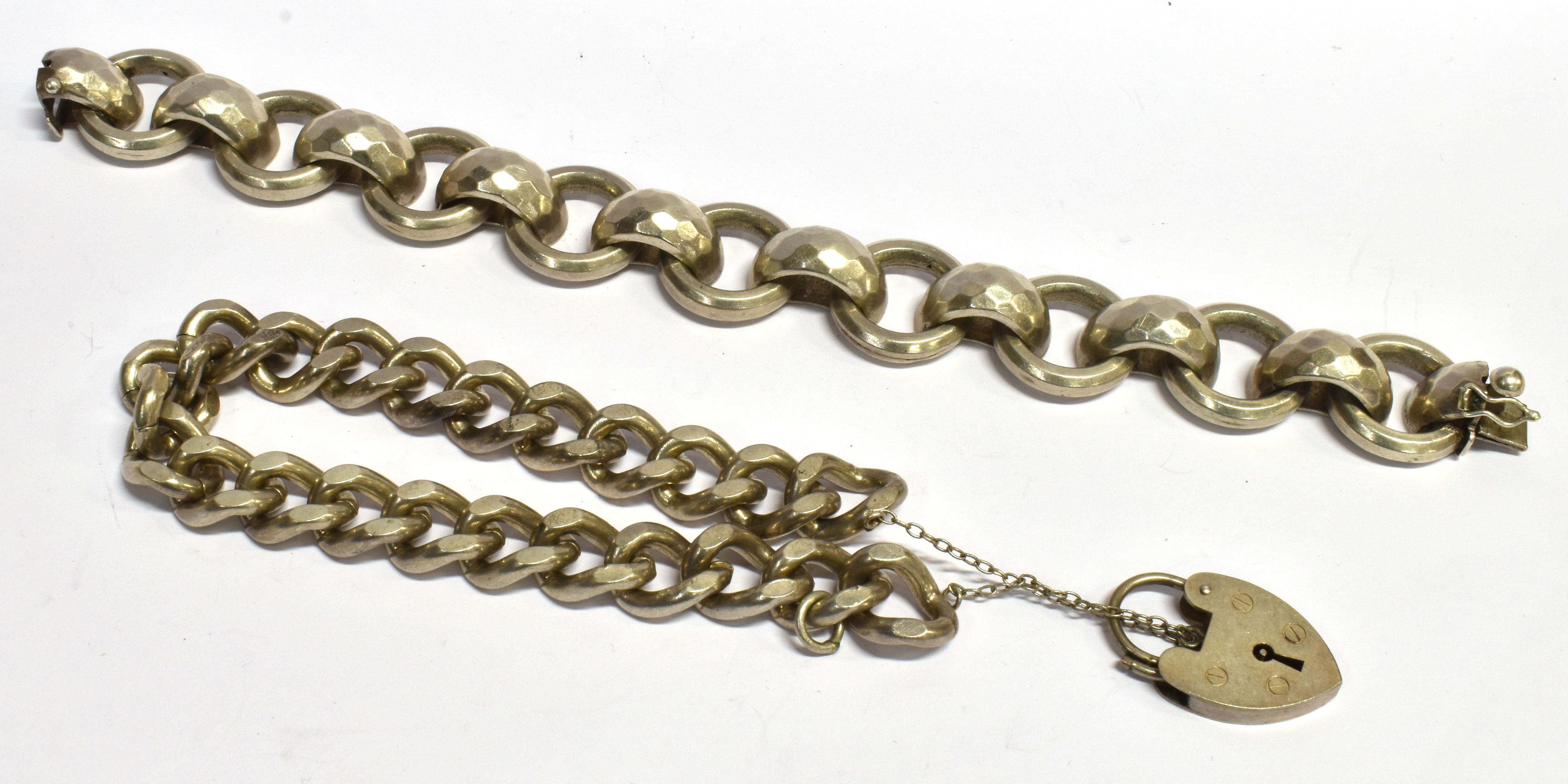 TWO SILVER BRACELETS comprising a curb link with padlock fastener and a fancy hoop and D link, total