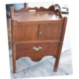 A GEORGE III MAHOGANY TRAY TOP COMMODE with a storage cupboard over a sliding base, 77cm high, 60.