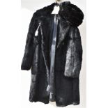 A LADY'S BLACK FUR COAT together with a black synthetic fur hat.