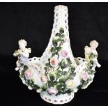 A CONTINENTAL PORCELAIN FIGURAL BASKET decorated with flowers and a pair of cherubs, underglaze blue