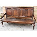 18TH CENTURY OAK SETTLE, with four panelled back, the solid seat flanked by down swept arms and