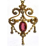 AN EDWARDIAN 15CT GOLD PENDANT/BROOCH the central oval cut rhodolite garnet 10mm x 7 mm with seed