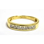 A DIAMOND HALF ETERNITY 18CT GOLD RING The channel set front containing 7 small set round