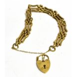 A 9CT GOLD GATE BRACELET with padlock fastener, the three bar gate links with seven small belcher