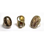 THREE SILVER STONE DRESS RINGS comprising a smoky quartz single stone, a garnet set three stone and