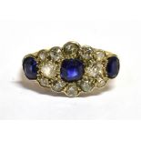 A SAPPHIRE AND DIAMOND 18CT YELLOW GOLD RING the boat shaped cluster comprising three sapphires with