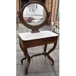 A FRENCH EMPIRE STYLE MARBLE TOP DRESSING TABLE the oval mirror supported by swans head terminals,