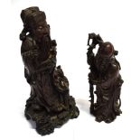 TWO CHINESE CARVED HARDWOOD FIGURES OF IMMORTALS: one holding staff and peach, 21cm high; the