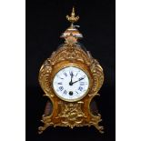 A CONTINENTAL ROCOCO STYLE MANTLE CLOCK the walnut case with gilt metal mounts with masks and