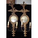 A PAIR OF GILDED TWO LIGHT GIRANDOLES the convex mirrors with eagle surmounts, 100cm high overall