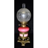A GOOD VICTORIAN OIL LAMP WITH SATIN GLASS RESERVOIR held in brass frame decorated with