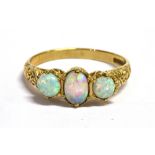 AN OPAL THREE STONE 9CT GOLD RING The centre opal 6mm x 4mm, claw set with scroll shoulder
