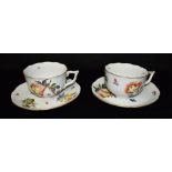 A PAIR OF HEREND PORCELAIN BREAKFAST CUPS AND SAUCERS decorated with flowers and fruit within