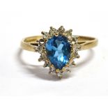 A BLUE TOPAZ AND DIAMOND PEAR SHAPED CLUSTER RING The central pear shaped blue topaz 7mm x 5mm and