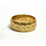 A 9CT GOLD PATTERNED WEDDING BAND set with small white stones, 8mm wide, size O, weighing approx.