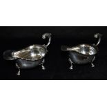 A PAIR OF SILVER SAUCE BOATS of traditional three footed design with scroll handles, hallmarked