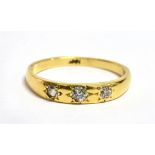 A DIAMOND THREE STONE 18CT GOLD BAND RING the three round old cut diamonds weighing a total of