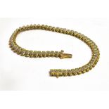 A 9CT GOLD BRACELET set with a central line of very small diamonds, the fancy yellow gold links to a