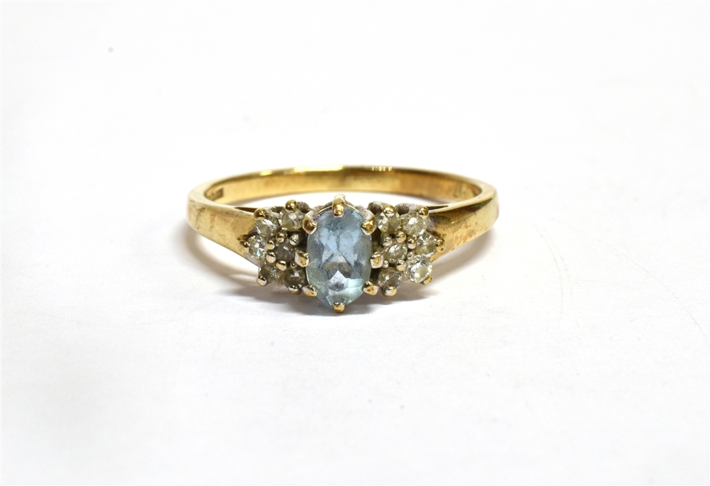 AN AQUAMARINE AND DIAMOND SET GOLD RING the central oval cut aquamarine approx. 6 x 4mm with six