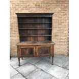 20TH CENTURY OAK DRESSER, the moulded cornice above a three shelf plate rack with panelled back