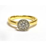 A HALF CARAT DIAMOND RING with halo cluster surround the central round brilliant cut diamond approx.