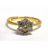 A DIAMOND CLUSTER 18CT GOLD RING The flower head cluster comprising seven round brilliant cut