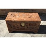 AN ORIENTAL CAMPHOR WOOD TRUNK, with carved decoration to the front and sides depicting boats and