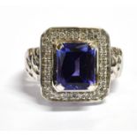 A MODERN TANZANITE AND DIAMOND CLUSTER 18CT WHITE GOLD RING The square cluster comprising a