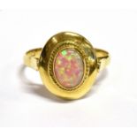 AN OPAL SINGLE STONE 14CT GOLD RING The oval cabochon cut opal 8mm x 6 mm bezel set to oval head and